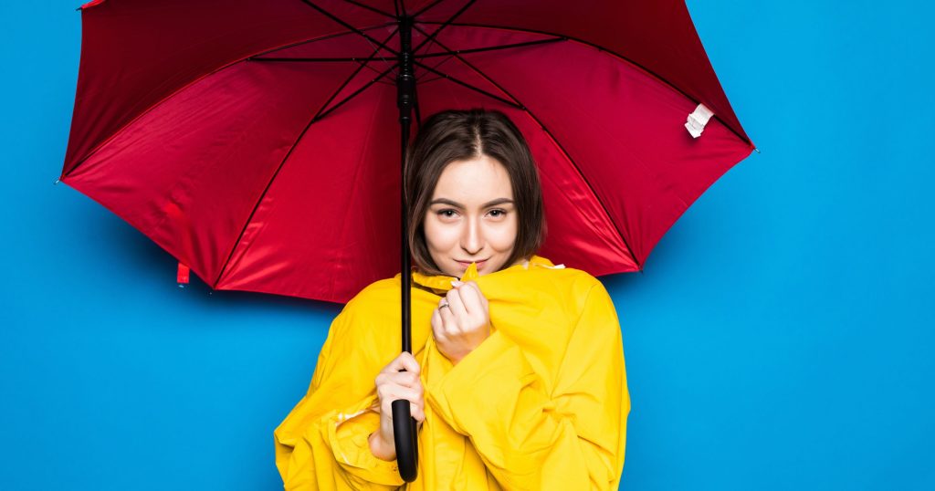 happy young woman holding umbrella